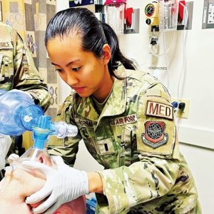 A soldier puts on a mask as another person receives an oxygen mask in a tense situation.