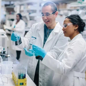 Two scientists in lab coats collaborating on a research project in a laboratory setting.