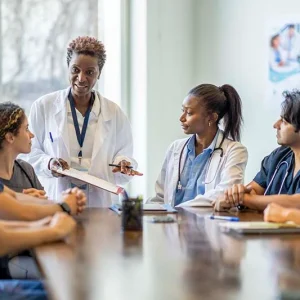 A group of doctors engaged in discussion while seated around a conference table.
